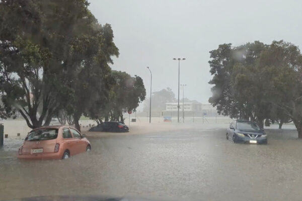 Cars are seen in a flooded street during heavy rainfall in Auckland, New Zealand January 27, 2023, in this screen grab obtained from a social media video. @MonteChristoNZ/via REUTERS