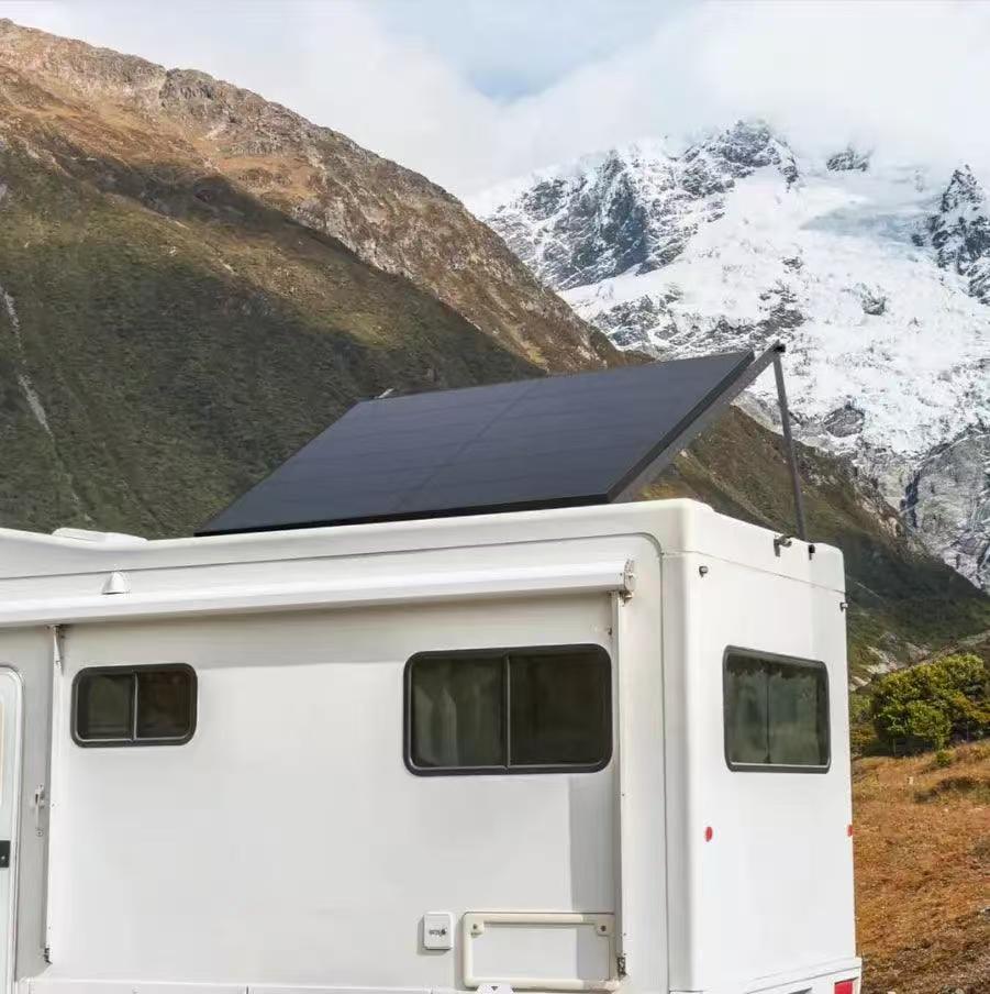 “Pair of rigid 400 W solar panels mounted on adjustable ground racks outside a field shelter, angled toward the sun to provide 800 W of off-grid power.”